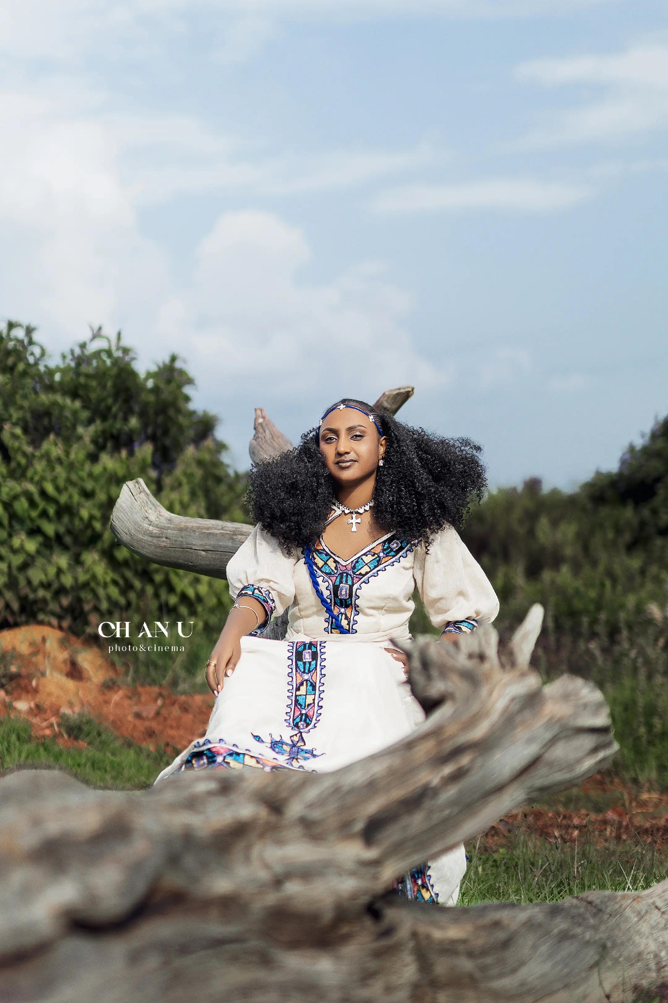 Ethiopian woman in traditional habesha dress with driftwood