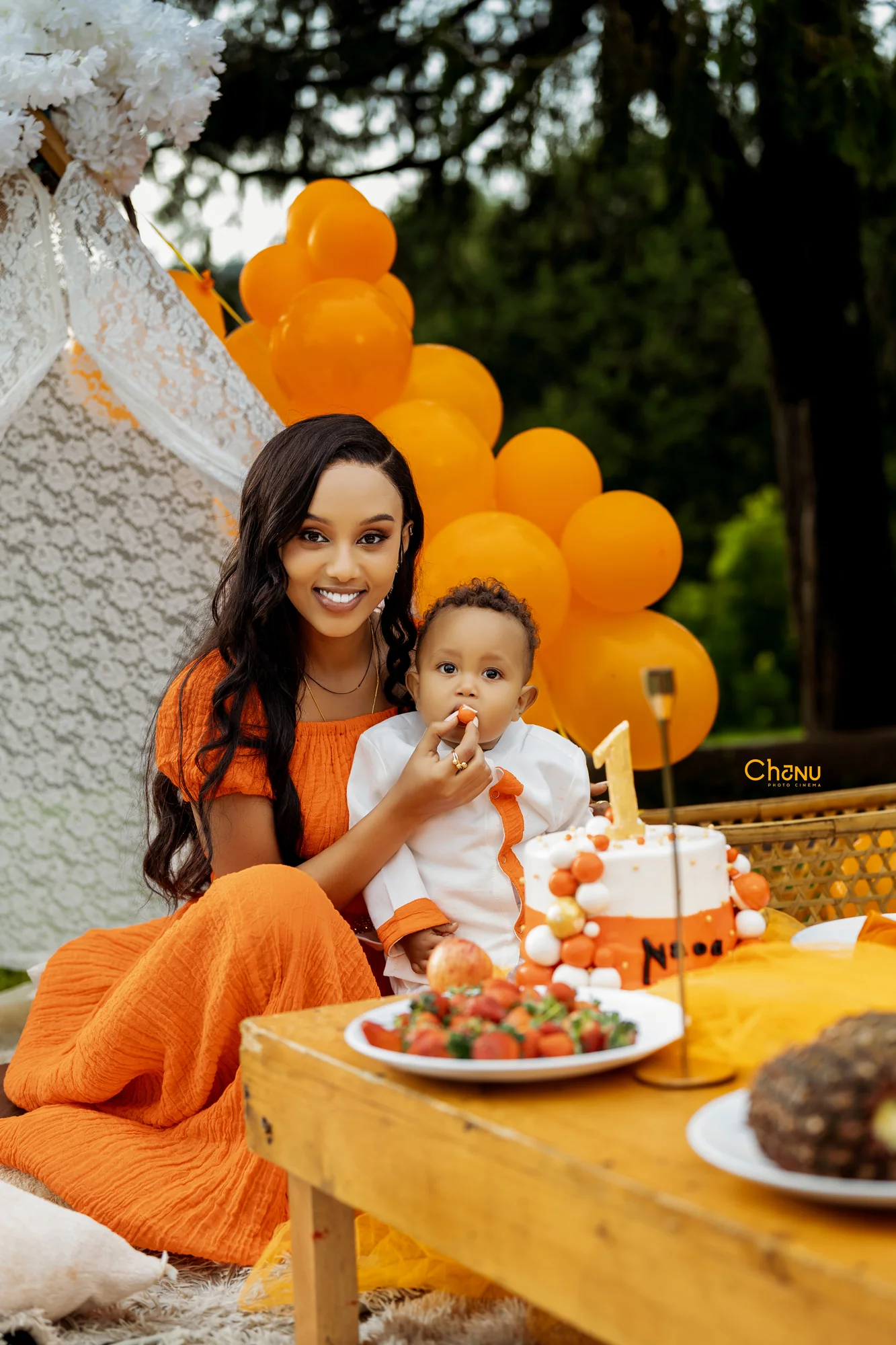 First birthday cake and mother tenderly feeding strawberry to baby Naod